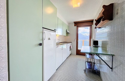 Verbier Apartment | A large entrance hall, living room with dining area and fireplace, kitchen with dishwasher, oven and