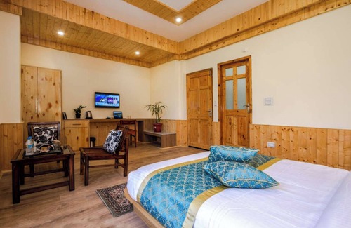 Manali Ski Chalet | Bedroom in a stone and wood chalet admist apple garden