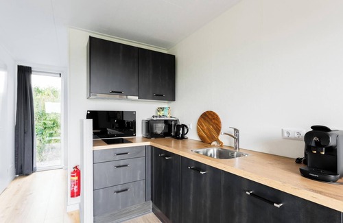 Gasselte House | Charming tiny house with a deck by the water. Relax, enjoy nature near ’t Nije Hemelriek and unwind – from sipping cappuccino in the sun to stargazing by the firepit.