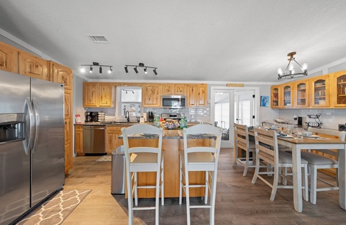 Butler Beach House | Cozy Canal Escape! Screen Covered Pool, Sunroom, Sun Deck, & Floating Boat Dock
