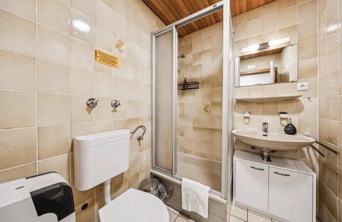 Wilhelmshaven Hotel | Cozy double room, seating area, flat-screen TV, and modern bathroom with shower. Ideal for couples and short stays – enjoy a relaxed atmosphere with warm wood accents and coastal charm.