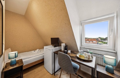 Wilhelmshaven Hotel | Cozy double room, flat-screen TV, and modern bathroom with shower. Ideal for couples and short stays – enjoy a relaxed atmosphere with warm wood accents and coastal charm.