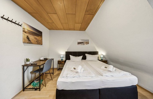 Wilhelmshaven Hotel | Cozy double room, flat-screen TV, and modern bathroom with shower. Ideal for couples and short stays – enjoy a relaxed atmosphere with warm wood accents and coastal charm.