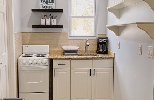 Coram Apartment | Cozy king suite with kitchen and dining area.