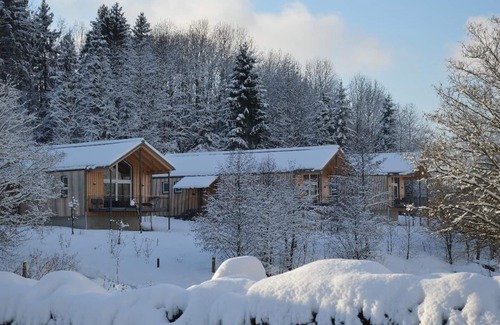 Bohmzwiesel Apartment | Ferienchalet mit überdachter Veranda mit Lounge Möbel und Schwebeliege.