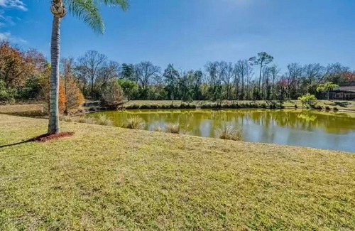 Lake Wilson Preserve House | Gorgeous water view from South facing pool deck. Balcony off upstairs master bed