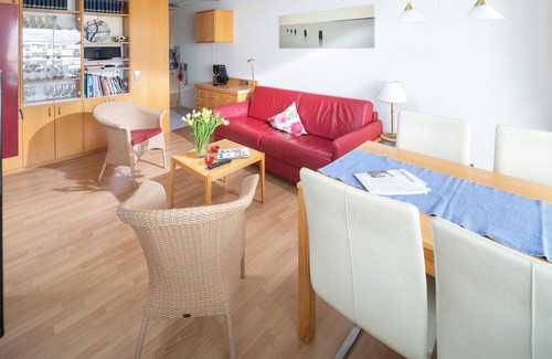Norderney Apartment | Großzügig Geschnittenen Balkon mit Schönem Holzbelag, mit 4 Bequemen Terrassenst