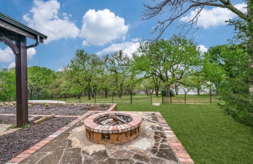 Little Elm House | Lakefront retreat just steps from Lake Lewisville! Enjoy 341 ft of shoreline, a private cove, sandy beach, fire pit, and pergola with built-in grill. Inside: lake views, travertine floors, cozy fireplace, and an upstairs game room with balcony.