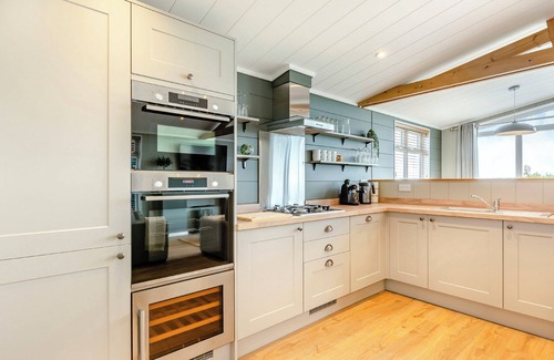 Middlezoy Ski Chalet | Luxurious lodge with vaulted ceilings and a welcoming feature fireplace.