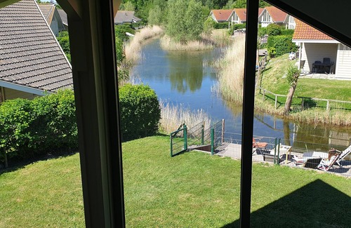 Kortgene Villa | Luxury detached vacation apartment by the river, lounge terrace and WLAN