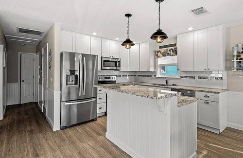 Fort Myers Beach House | Ostego Charm: Open floor plan, porch, lush landscape—walk-able to the Beach!