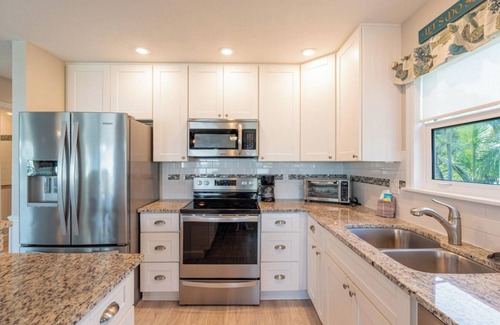 Fort Myers Beach House | Ostego Charm: Open floor plan, porch, lush landscape—walk-able to the Beach!