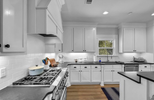 Saint Simons Island House | Private expansive backyard with pool, putting green and outdoor kitchen