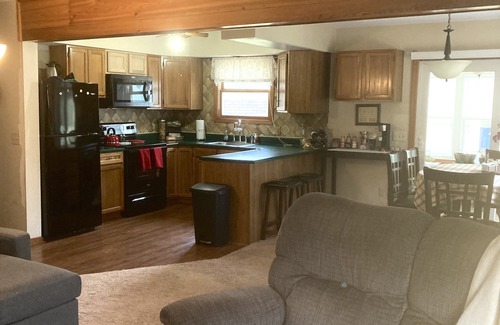 Lake House | Roomy home with spacious fenced in backyard and fire pit.