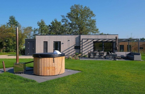 Kotten House | The Amalia is a 4-bed vacation home with a cozy homey living room, an open kitchen, 2 bedrooms, a generous outdoor space, and a hot tub.