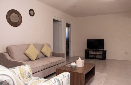 Ragged Point Apartment | The apartment features an open plan living and dining area, and a spacious and modern kitchen.