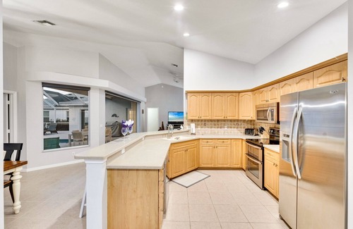 Central Naples House | This 3/2 home enjoys a Southwest facing lakefront view with pool and spa