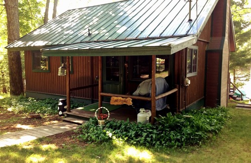 South Boardman Cottage | Traverse City area Lakefront Log Home, FREE Hot Tub, WIFI, & Boats.