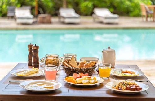 Glacis Apartment | Warm Creole Styled Room With Tropical Flowers