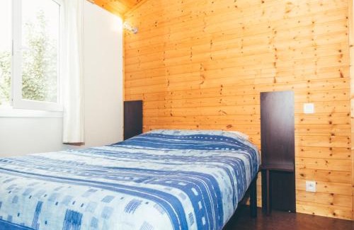 Beynat Ski Chalet | Wooden chalet with covered terrace on the edge of a lake