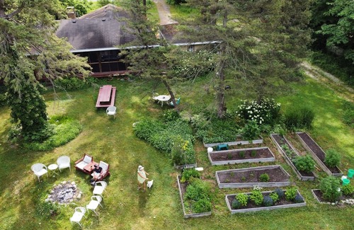 Three Oaks House | You're in a hot tub; you see gardens and hear wind blowing through the pines.
