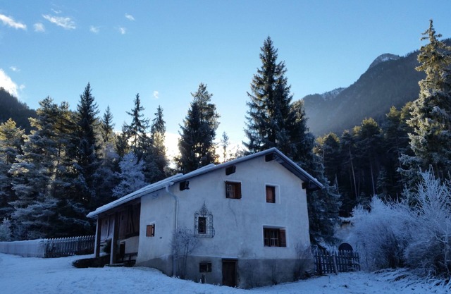Ancient typical Engadine mill on a stream near the woods and walks
