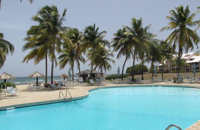 Caribbean colors on wide open estate on a long sandy swimming beach.