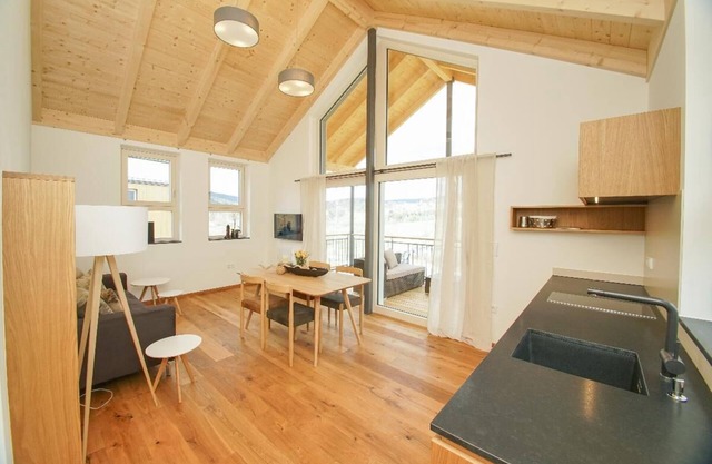 Ferienchalet mit überdachter Veranda mit Lounge Möbel und Schwebeliege.