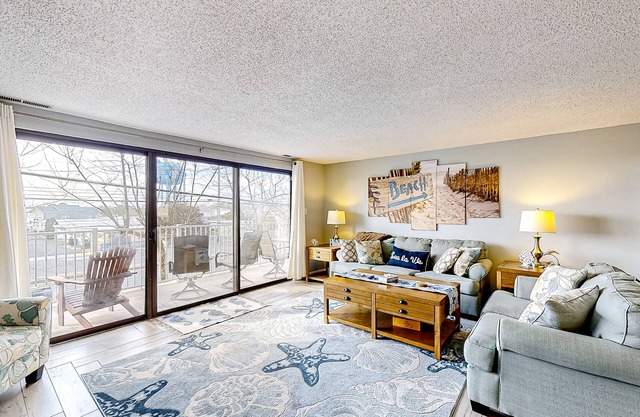 Inviting coastal condo with pool, balcony, full kitchen, & W/D
