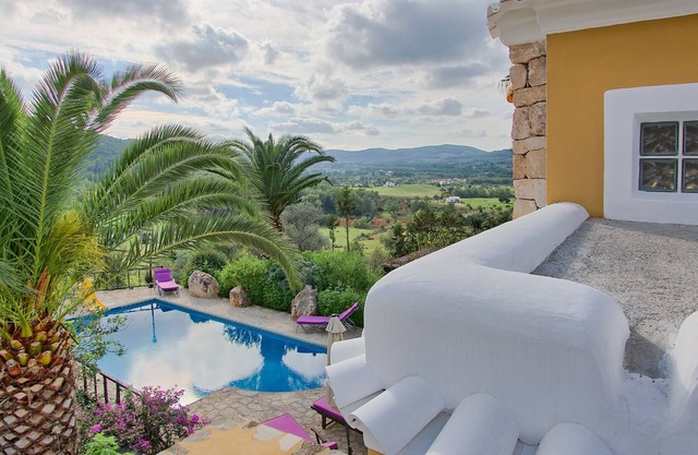 Original restored stone-wood ibizan country villa with pool facing sunset.