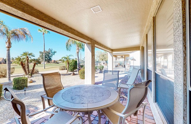 Palm-lined home with pool access, grill, office & golf course views