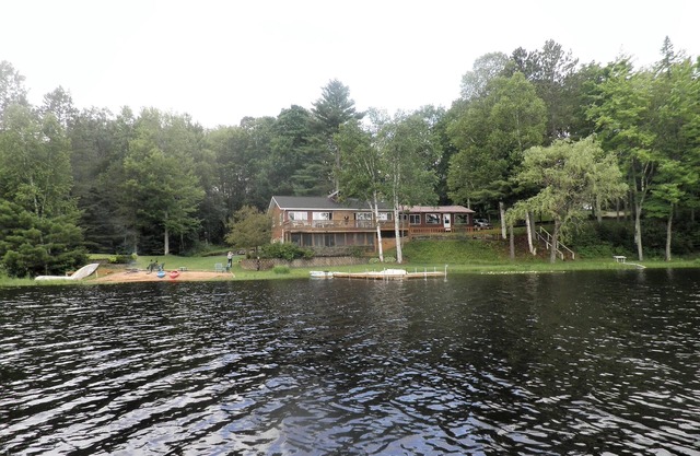 SECLUDED LODGE WITH ONE OF THE LARGEST PRIVATE STOCKED LAKES IN MICHIGAN.