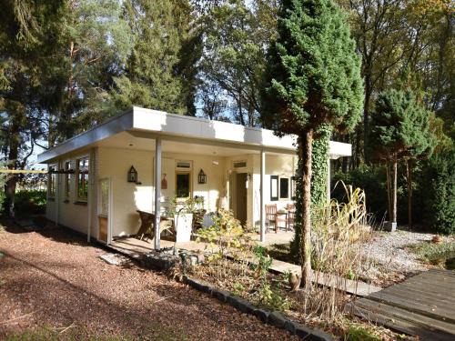 Wateren House | A detached bungalow with outdoor fireplace, covered terrace and pond in a forest plot