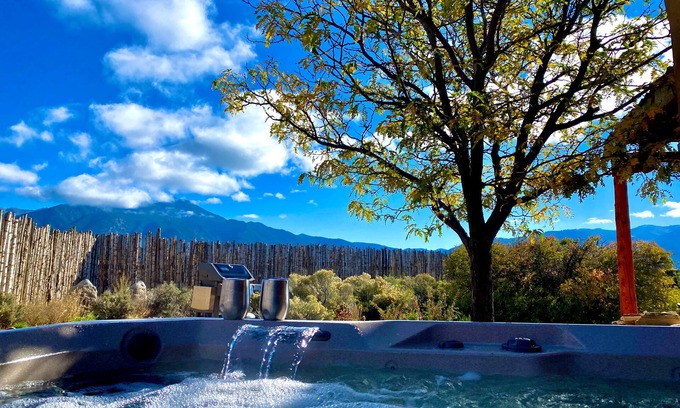 Taos House | Colorful dog-friendly home with sweeping views, a private hot tub, & large yard