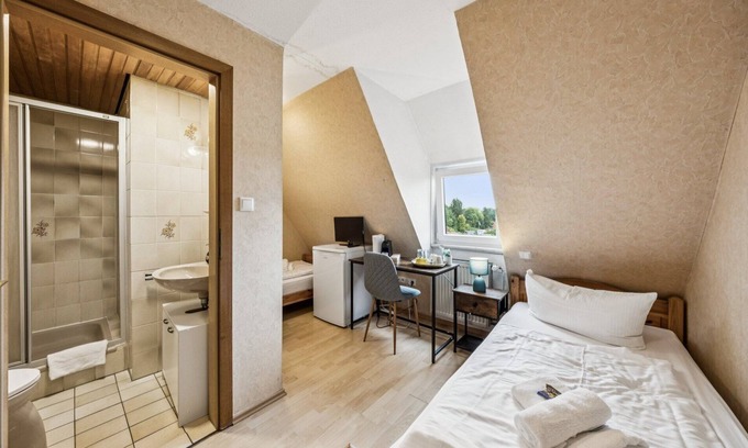 Wilhelmshaven Hotel | Cozy double room, flat-screen TV, and modern bathroom with shower. Ideal for couples and short stays – enjoy a relaxed atmosphere with warm wood accents and coastal charm.