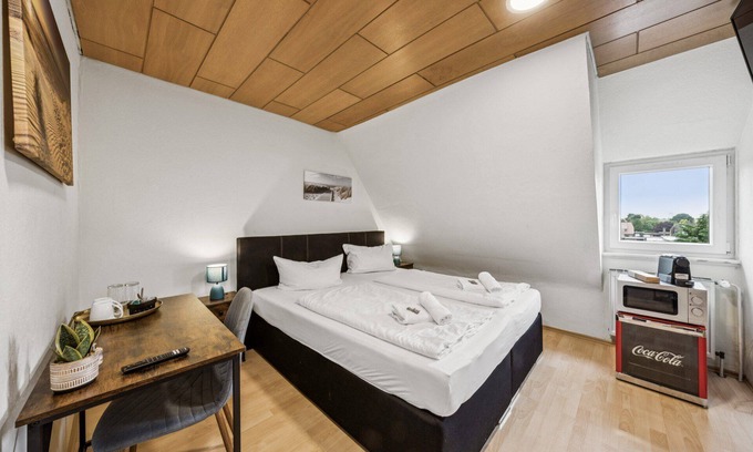 Wilhelmshaven Hotel | Cozy double room, flat-screen TV, and modern bathroom with shower. Ideal for couples and short stays – enjoy a relaxed atmosphere with warm wood accents and coastal charm.
