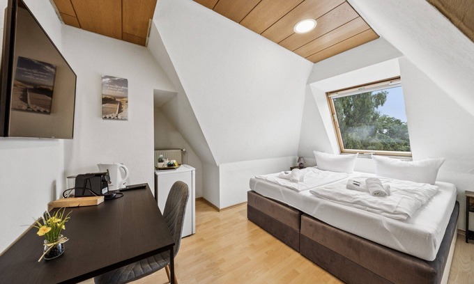 Wilhelmshaven Hotel | Cozy double room, flat-screen TV, and modern bathroom with shower. Ideal for couples and short stays – enjoy a relaxed atmosphere with warm wood accents and coastal charm.