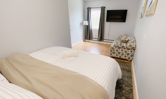 Coram Apartment | Cozy king suite with kitchen and dining area.