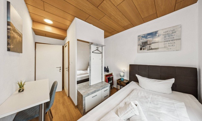 Wilhelmshaven Hotel | Cozy single room, flat-screen TV, and modern bathroom with shower. Ideal for singles and short stays – enjoy a relaxed atmosphere with warm wood accents and coastal charm.