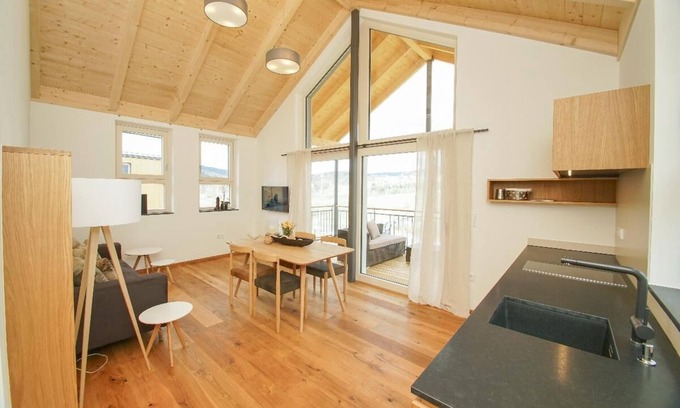 Bohmzwiesel Apartment | Ferienchalet mit überdachter Veranda mit Lounge Möbel und Schwebeliege.