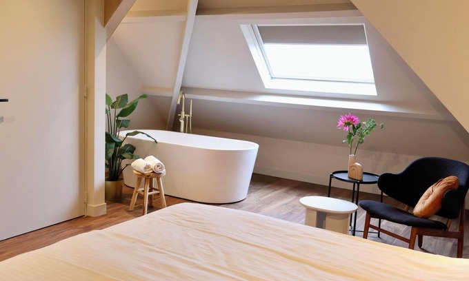 Appeltern Hotel | Luxurious family suite with river meadow views, a bathtub, and modern amenities for a relaxing family getaway.