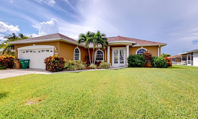 Cape Coral House | Waterfront home with screened pool, patio, grill, foosball, AC, & W/D