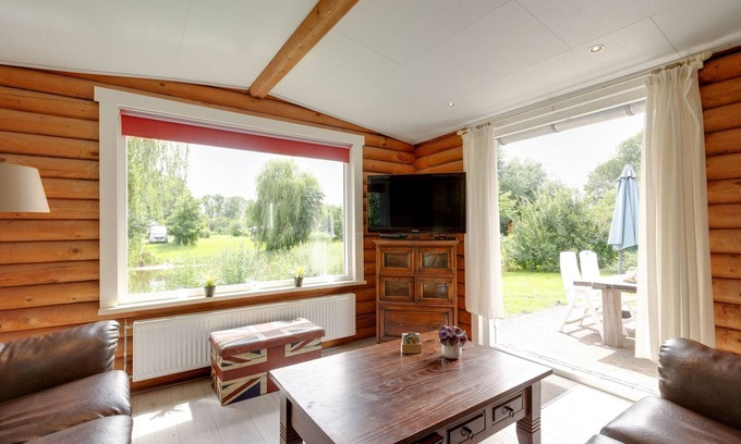 De Kolonie House | Wooden tree trunk bungalow at fish pond